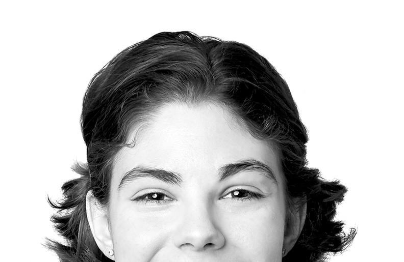 A person with short hair is smiling at the camera. We can see their eyes and nose, but the photo is cropped above their mouth.